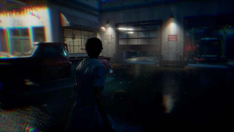 A resident walking past parked cars in front of Phelps Garage at night